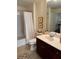 This bright bathroom with a shower/tub combo features a dark vanity, mirror, and a view of the living room at 230 E Ponce De Leon Ave # 210, Decatur, GA 30030