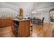 Modern kitchen featuring an island with an oven, granite countertops, and an adjacent dining area for easy entertaining at 216 Crescent Moon Way, Canton, GA 30114