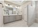 Elegant bathroom featuring double vanity, a large mirror, and a luxurious tiled shower at 5225 Ginger Rose Ct, Cumming, GA 30028