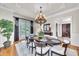 Elegant dining room featuring a chandelier, wainscoting, and access to an outdoor balcony at 2867 Darlington Run, Duluth, GA 30097