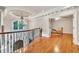 Upstairs hallway with hardwood floors and chandelier, leading to a room with chair and desk at 2867 Darlington Run, Duluth, GA 30097