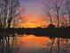Scenic view of a pond reflecting a vibrant sunset through bare trees at 2867 Darlington Run, Duluth, GA 30097