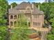 Expansive brick home featuring a stone pool, balconies, and lush landscaping at 2867 Darlington Run, Duluth, GA 30097