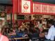A vibrant restaurant scene with patrons enjoying food under eye-catching, red-themed decor at 628 Skytop Dr # 158, Cumming, GA 30040