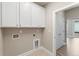 Functional laundry room with white cabinets and utility connections for washer and dryer at 248 Persimmon Dr, Holly Springs, GA 30115