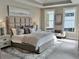 Luxurious main bedroom featuring a tray ceiling, soft carpet, and a large bed with a padded headboard and plush pillows at 248 Persimmon Dr, Holly Springs, GA 30115