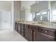 Granite countertop bathroom vanity with dark cabinetry, double sinks, and a large mirror at 1068 W Union Grove Cir, Auburn, GA 30011