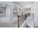 Bright upstairs hallway with carpet, featuring wood and iron railing, arched doorways, and neutral paint at 1068 W Union Grove Cir, Auburn, GA 30011
