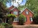 Charming two-story red brick home featuring classic black shutters and lush, mature landscaping at 2631 Gladstone Ter, Woodstock, GA 30189