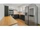 A modern kitchen with stainless steel appliances, sleek cabinets, and a butcher block countertop for a chef-inspired design at 6584 Sleepy Hollow Ln, Morrow, GA 30260