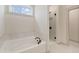 Bathroom featuring a soaking tub and walk-in shower, both adorned with marble tile at 111 Henley St, Canton, GA 30114