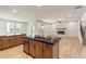 Kitchen island with black countertop and brass faucet is adjacent to the bright living room with a modern fireplace at 111 Henley St, Canton, GA 30114