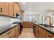 Well-equipped kitchen featuring wood cabinets, black countertops, and stainless steel appliances at 111 Henley St, Canton, GA 30114