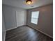 A well-lit bedroom with wood-look flooring, a double closet, and a window at 500 Mica Trce, South Fulton, GA 30349