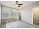 Bright bedroom with a ceiling fan, three windows and neutral walls at 1095 Tucker Ave # 401, Atlanta, GA 30310