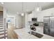 Bright kitchen features stainless appliances, white cabinets, granite countertops, and modern globe pendant lights at 1095 Tucker Ave # 401, Atlanta, GA 30310