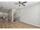 Open-concept living room with wood floors, stairway, and a view into the modern kitchen at 1095 Tucker Ave # 401, Atlanta, GA 30310