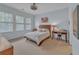Comfortable bedroom featuring three windows, a bed, and a desk with a stool at 3621 Vinings Slope Se # 3202, Atlanta, GA 30339