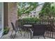 Private patio with metal chairs and a table, surrounded by lush greenery at 3621 Vinings Slope Se # 3202, Atlanta, GA 30339