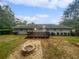 View of backyard with deck, fire pit, stone pavers, and mature trees on a cloudy day at 720 Smithstone Se Rd, Marietta, GA 30067