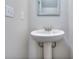 Close-up of a pedestal sink in a bathroom featuring a framed mirror and classic fixtures for a clean, minimalist aesthetic at 3405 Ripple Loop # 127, South Fulton, GA 30349