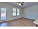 Open bedroom featuring wood-look floors, a ceiling fan, with natural light streaming in from large windows and the glass pane door at 3405 Ripple Loop # 127, South Fulton, GA 30349