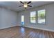 Bright bedroom featuring wood-look floors, a ceiling fan, and natural light streaming through large windows and the glass pane door at 3405 Ripple Loop # 127, South Fulton, GA 30349