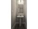 Stylish half bathroom featuring a pedestal sink, gray framed mirror, and modern lighting fixtures at 3405 Ripple Loop # 127, South Fulton, GA 30349
