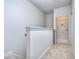 Upstairs hallway featuring carpet flooring leading to a laundry room with white walls and trim at 3405 Ripple Loop # 127, South Fulton, GA 30349