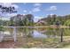 Backyard view with a tranquil lake surrounded by lush trees and a charming house in the distance at 2675 Drayton Hall Dr, Buford, GA 30519