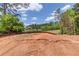 A backyard overlooking a serene lake view with lush trees and a glimpse of a distant home at 2675 Drayton Hall Dr, Buford, GA 30519