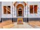 The front entrance with arched doorway and wood framing features a staircase and natural lighting at 2675 Drayton Hall Dr, Buford, GA 30519