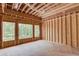 Unfinished interior featuring exposed wood framing, multiple windows and natural light from the trees outside at 2675 Drayton Hall Dr, Buford, GA 30519