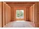 Unfinished room features exposed framing with window showcasing natural landscape views, awaiting customization at 2675 Drayton Hall Dr, Buford, GA 30519