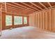 Unfinished room featuring exposed framing, wood subfloor, with windows offering views of the natural landscape at 2675 Drayton Hall Dr, Buford, GA 30519