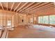 Unfinished interior showcasing exposed framing, wood subfloor, and natural light from the window at 2675 Drayton Hall Dr, Buford, GA 30519