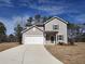 Charming two-story home with a two-car garage, landscaped yard, and a long concrete driveway at 8659 Paradise Dr, Douglasville, GA 30134
