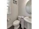Elegant powder room with a pedestal sink, round mirror, and tiled floor at 550 Whitlox Nw Rd, Atlanta, GA 30318