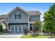 Two-story home with a gray exterior, two-car garage, and a fenced patio at 330 Wagon Way, Alpharetta, GA 30009