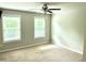 Bright, carpeted bedroom with ample natural light from two windows and a ceiling fan for added comfort at 389 Meeting St, Mcdonough, GA 30252