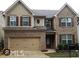 Two-story brick house with a two-car garage, dark shutters, and manicured landscaping at 389 Meeting St, Mcdonough, GA 30252