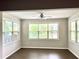 Inviting living room featuring hardwood floors, neutral paint, large windows, and a ceiling fan at 389 Meeting St, Mcdonough, GA 30252