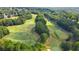 Aerial view of lush green golf course with trees and a walking bridge at 503 W Green Ct, Woodstock, GA 30189