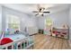Bright bedroom with a ceiling fan, two windows, and a closet with toys at 626 Dover St, Marietta, GA 30066