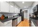 Modern kitchen featuring sleek black countertops, stainless steel appliances, and hardwood floors at 626 Dover St, Marietta, GA 30066