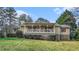 Charming home featuring a covered front porch, white railings, red shutters, and mature landscaping at 2601 Round Ridge Rd, Loganville, GA 30052