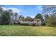 Quaint single-story home boasts a full-length front porch, complemented by a lush green lawn and mature trees at 2601 Round Ridge Rd, Loganville, GA 30052