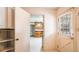 Hallway with a view of the kitchen and a pantry with white shelves, next to a door with a window at 2601 Round Ridge Rd, Loganville, GA 30052