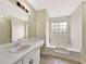 Bright bathroom featuring a soaking tub, large mirror, and white vanity at 277 Players Cir, Fayetteville, GA 30215