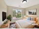 Bright bedroom featuring a plush bed, plants, and a scenic view from the window at 277 Players Cir, Fayetteville, GA 30215